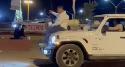 Captan a alcalde de Coahuila paseando en el cofre de una camioneta de lujo con una bebida en la mano