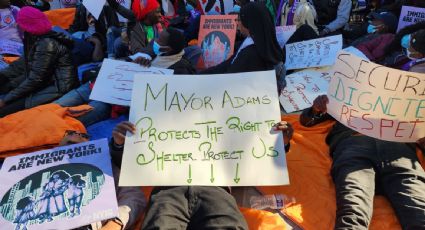 Migrantes simulan dormir frente a la residencia del alcalde de Nueva York en protesta por la eliminación del derecho al refugio
