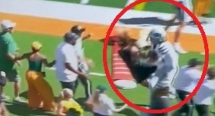 ¡Suelo! Reportera de televisión recibe brutal embestida de un quarterback en el futbol americano colegial