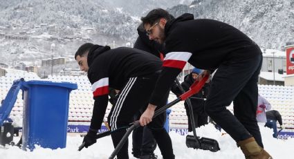 Gerard Piqué, dueño mayoritario del Andorra, trabaja junto a su novia y aficionados para quitar la densa capa de nieve de la cancha para jugar su partido