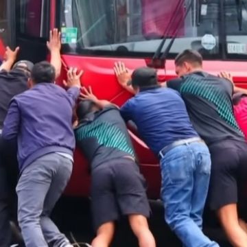 Futbolistas del Club Atlético La Paz ayudan a empujar un Metrobús que estorbaba su paso en la CDMX